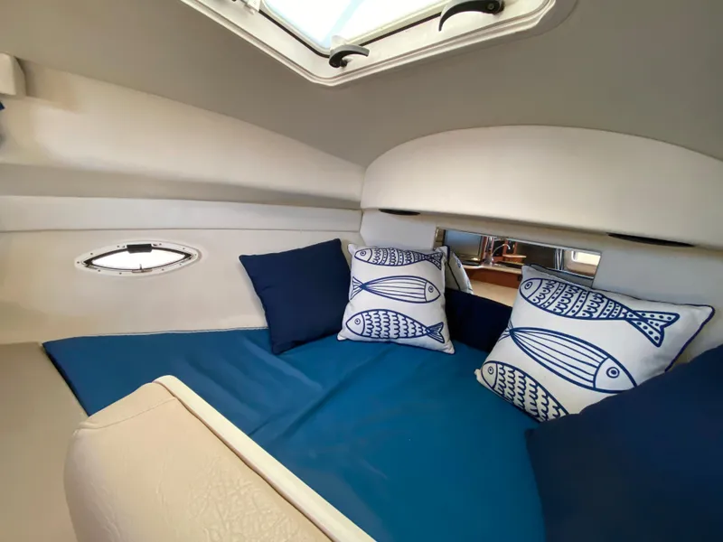Slide: The Image of Interior of a 2003 Bayliner 265 with blue cushions and fish motifs. - 20