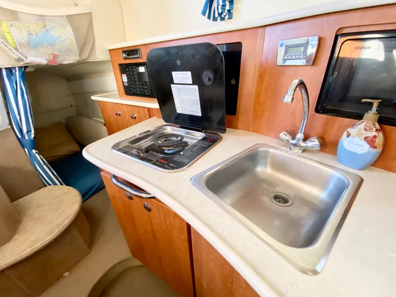 Slide: The Image of 2003 Bayliner 265 yacht kitchen area with sink and stove. - 22