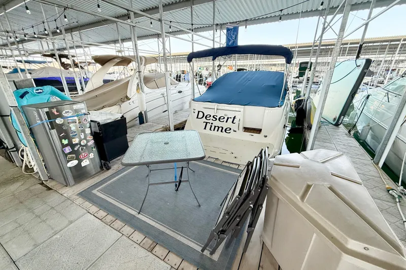 Slide: The Image of 2003 Bayliner 265 boat named "Desert Time" docked with outdoor setup. - 38