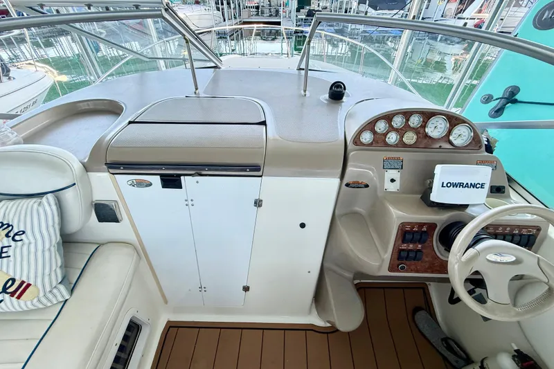Slide: The Image of 2003 Bayliner 265 boat cockpit with steering wheel, gauges, and Lowrance navigation system. - 5