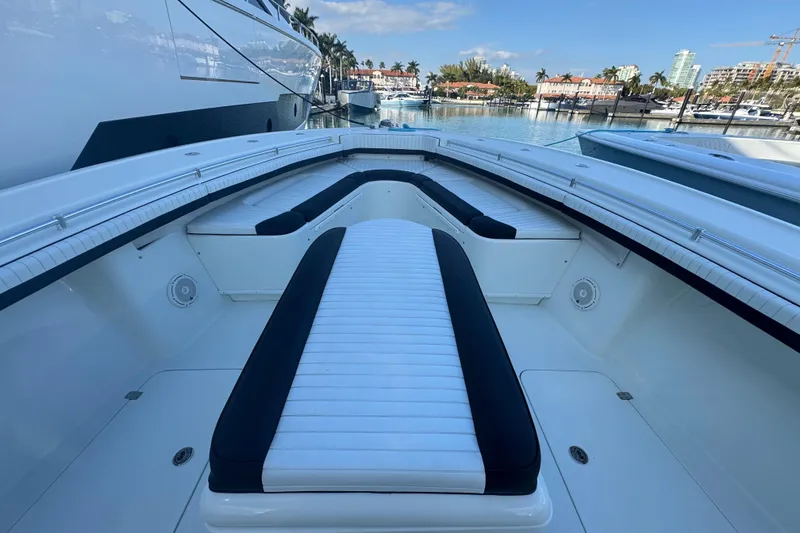 Slide: The Image of 2014 Yellowfin 39 Offshore boat interior with cushioned seating, docked in a marina. - 10