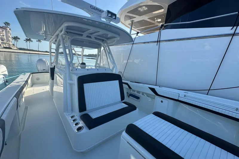 Slide: The Image of 2014 Yellowfin 39 Offshore boat interior with seating and Garmin equipment, docked by water. - 13