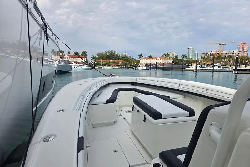 Slide: The Image of 2014 Yellowfin 39 Offshore boat docked in a marina with scenic city backdrop. - 14