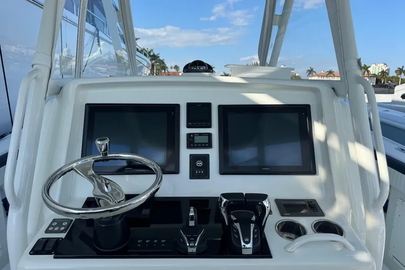 Slide: The Image of 2014 Yellowfin 39 Offshore boat dashboard with dual screens and steering wheel. - 3