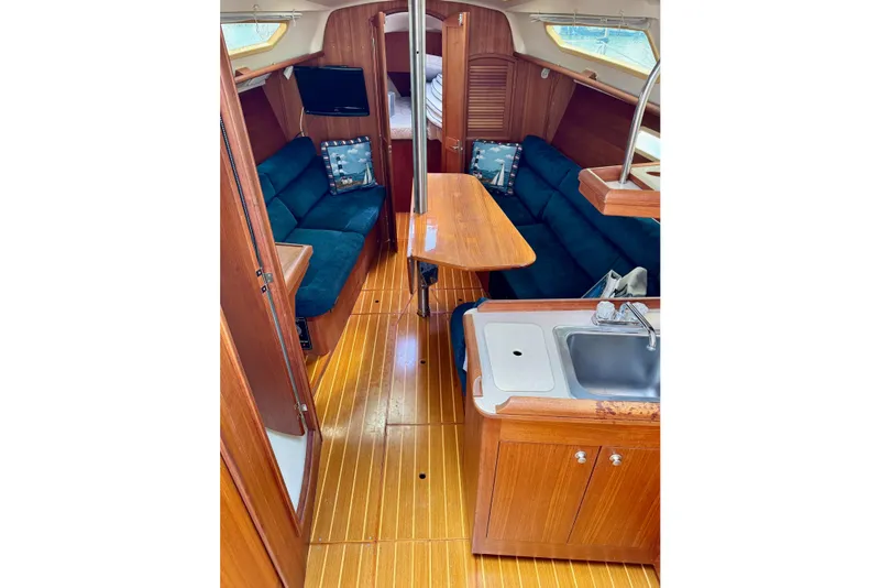 Slide: The Image of Interior of 2001 Hunter 320 sailboat with wooden finish and cozy seating area. - 14
