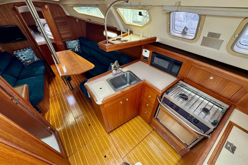 Slide: The Image of Interior of a 2001 Hunter 320 sailboat with kitchen and seating area. - 15