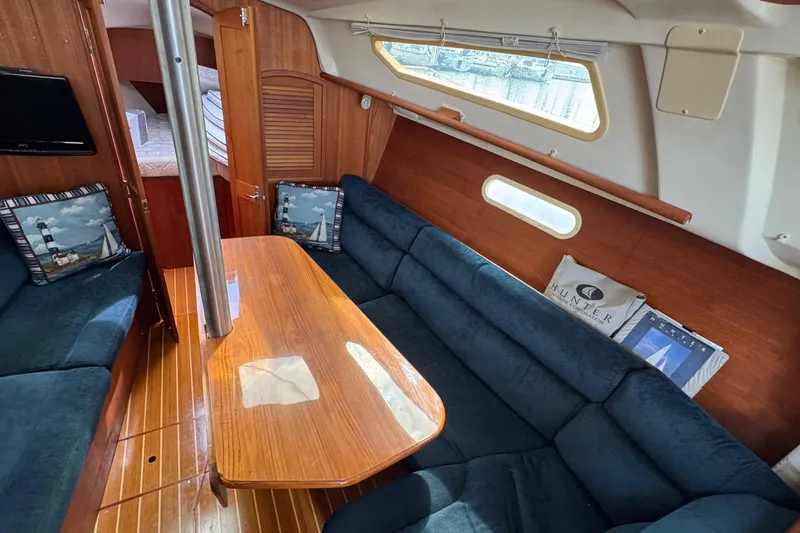 Slide: The Image of Interior of 2001 Hunter 320 sailboat with cozy seating and wooden table. - 16