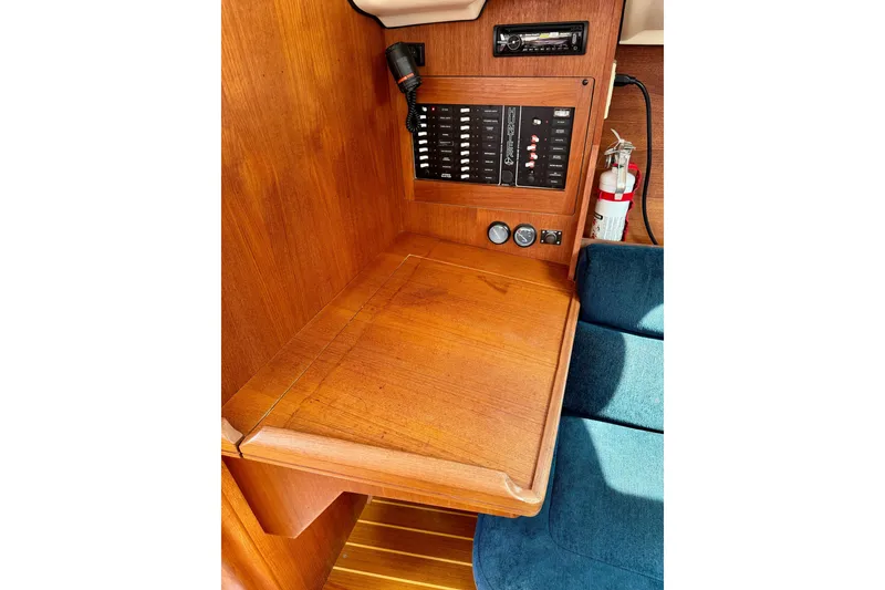 Slide: The Image of Wooden navigation station in a 2001 Hunter 320 sailboat with control panel and fire extinguisher. - 21