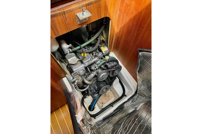 Slide: The Image of Engine compartment of a 2001 Hunter 320 sailboat, showcasing mechanical components and belts. - 25