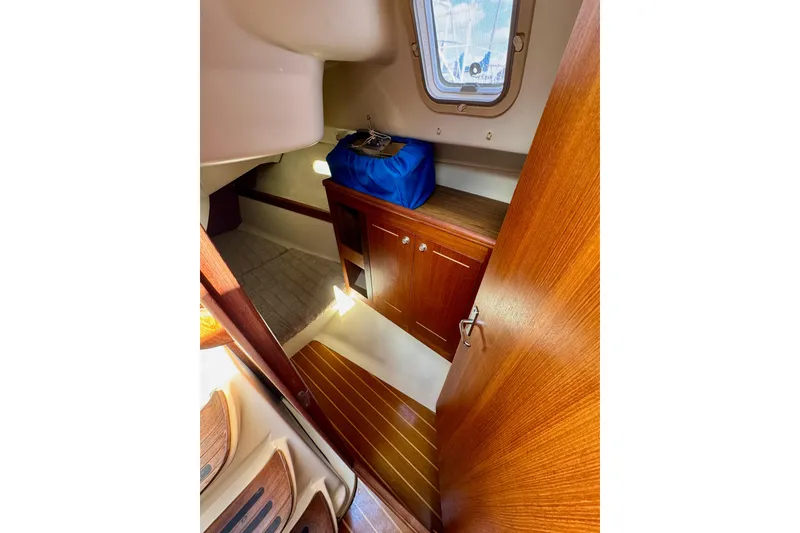 Slide: The Image of Interior of 2001 Hunter 320 sailboat with wooden cabinetry and a small window. - 27