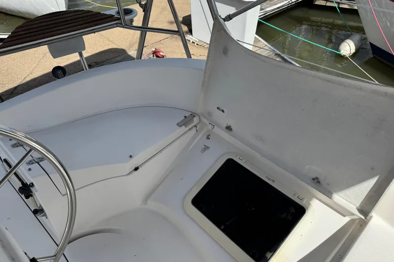 Slide: The Image of Cockpit of 2001 Hunter 320 sailboat with open storage compartment. - 31