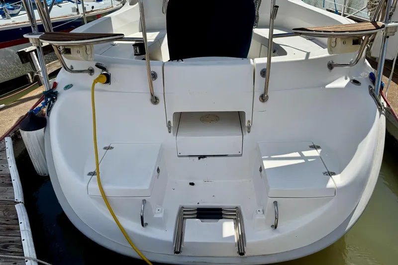 Slide: The Image of Rear view of 2001 Hunter 320 sailboat docked, featuring swim platform and ladder. - 32