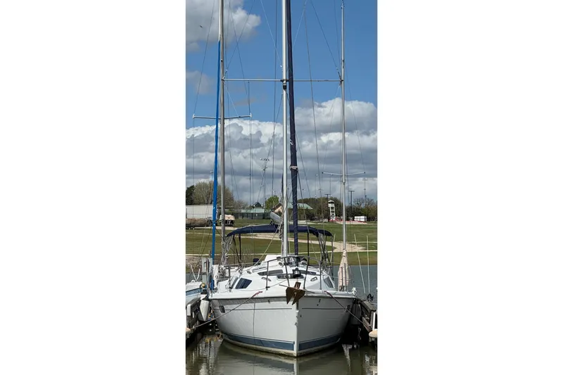 Slide: The Image of 2001 Hunter 320 sailboat docked under a blue sky with clouds. - 5