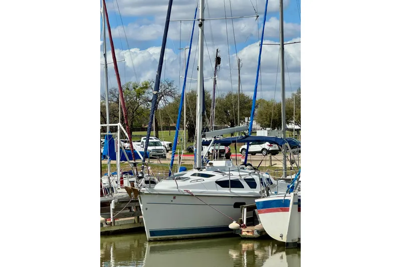 Slide: The Image of Sailboat docked at marina, Hunter 320 model, 2001, with blue and white accents. - 6