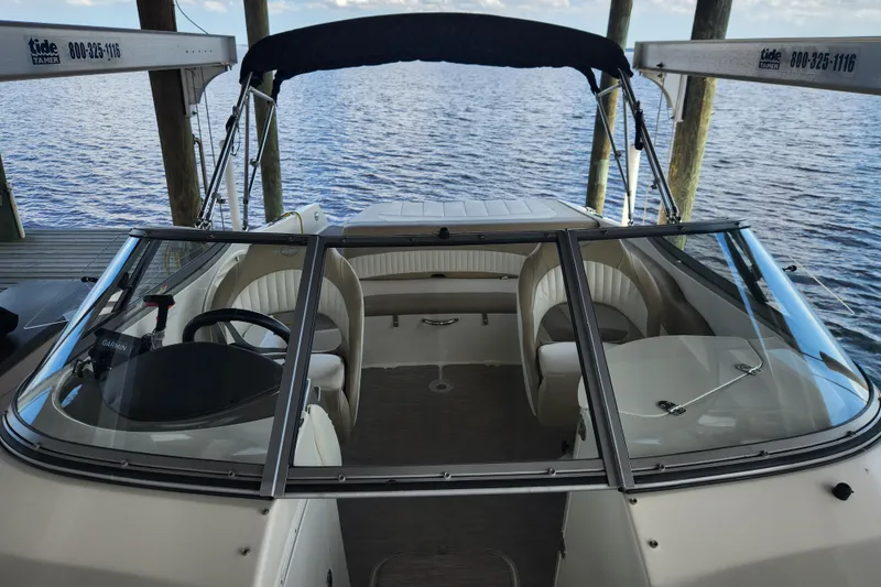 Slide: The Image of 2018 Stingray 235 LR boat docked, featuring spacious seating and sleek design. - 13