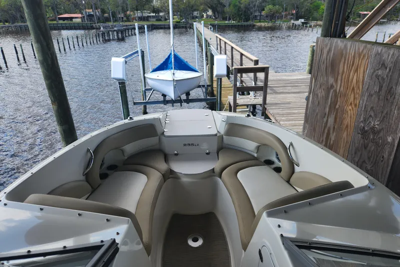 Slide: The Image of 2018 Stingray 235 LR boat docked, featuring spacious seating and sleek design. - 15