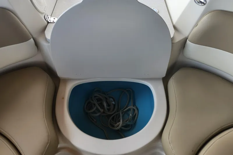 Slide: The Image of 2018 Stingray 235 LR boat storage compartment with coiled rope inside. - 23