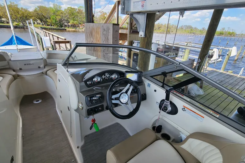 Slide: The Image of Interior of a 2018 Stingray 235 LR boat, featuring steering wheel and dashboard controls. - 30