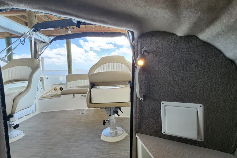 Slide: The Image of Interior view of a 2018 Stingray 235 LR boat with beige seating and cabin lighting. - 36