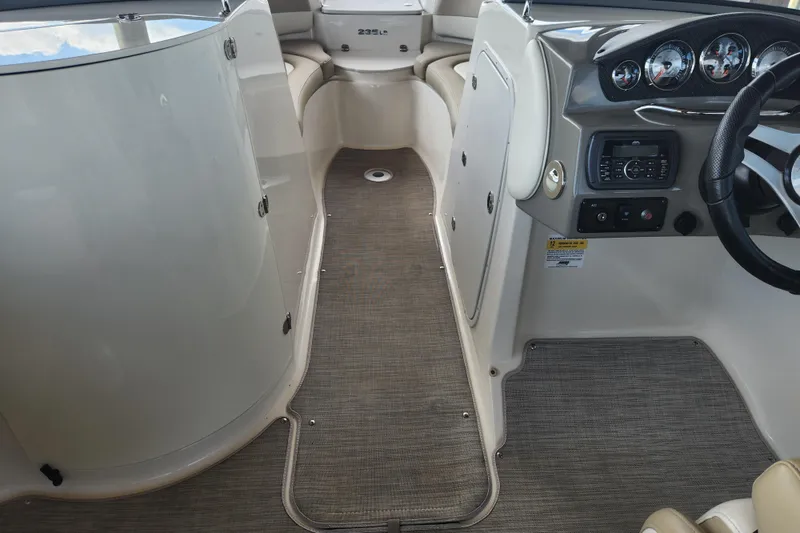 Slide: The Image of 2018 Stingray 235 LR boat interior with dashboard and seating area. - 38