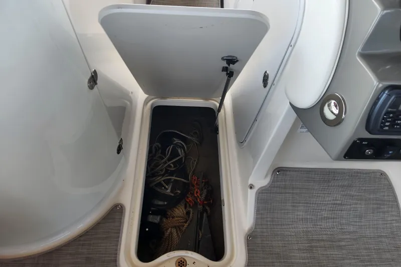 Slide: The Image of Open storage compartment on 2018 Stingray 235 LR boat, containing ropes and equipment. - 39