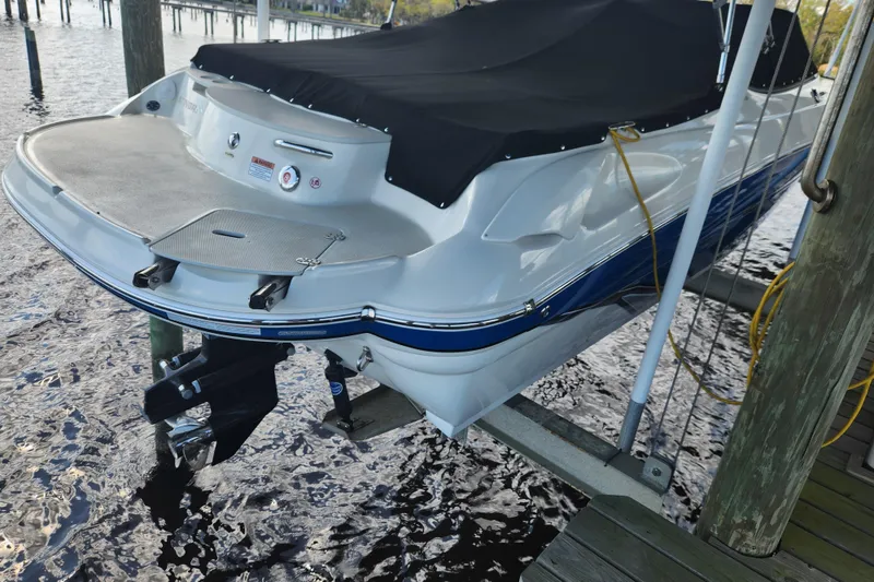 Slide: The Image of 2018 Stingray 235 LR boat docked, covered, and elevated above water. - 4