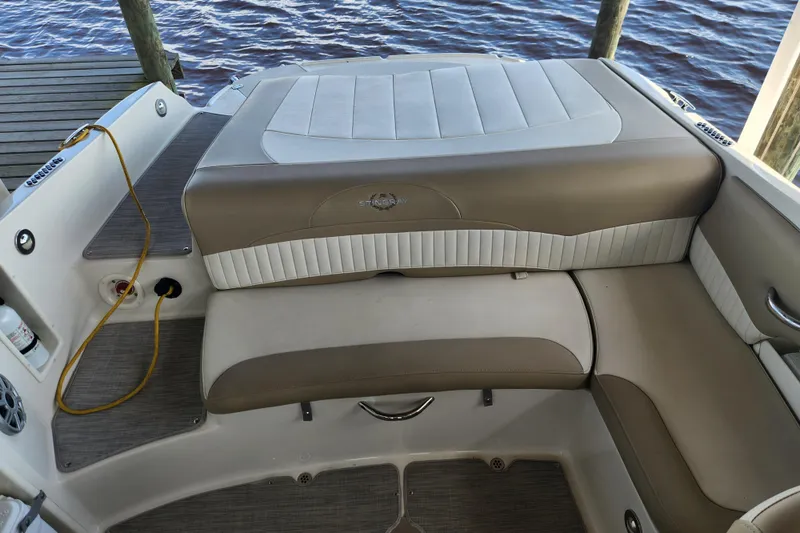 Slide: The Image of 2018 Stingray 235 LR boat interior with beige and white seating, docked by water. - 43