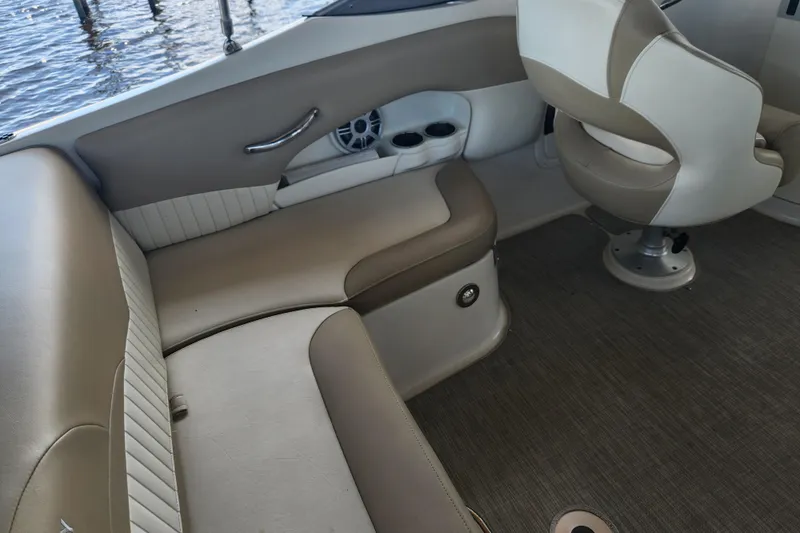 Slide: The Image of 2018 Stingray 235 LR boat interior with beige seating and cup holders. - 47