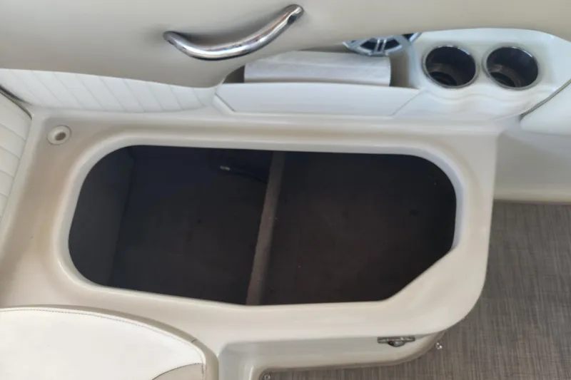 Slide: The Image of 2018 Stingray 235 LR boat interior storage compartment with cup holders and speaker. - 48