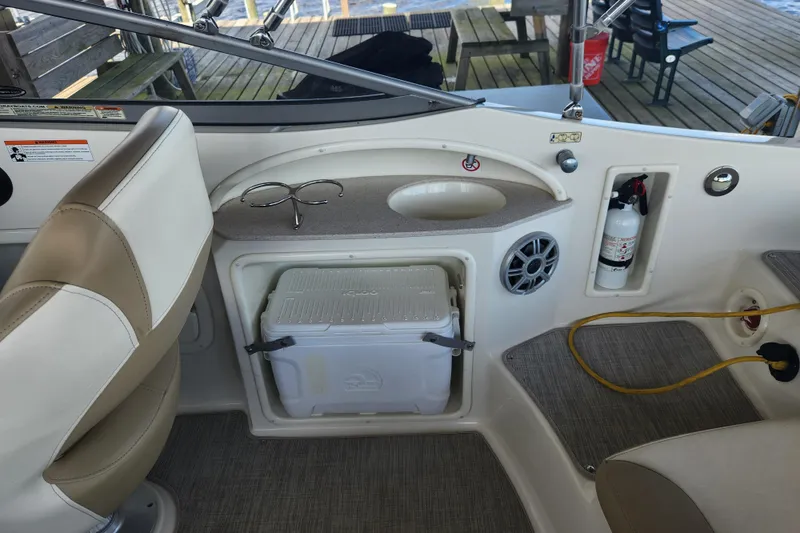 Slide: The Image of 2018 Stingray 235 LR boat interior with cooler, fire extinguisher, and seating area. - 49