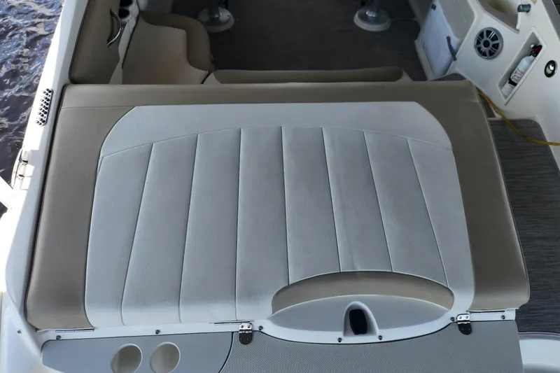 Slide: The Image of 2018 Stingray 235 LR boat interior with cushioned seating and cup holders. - 52