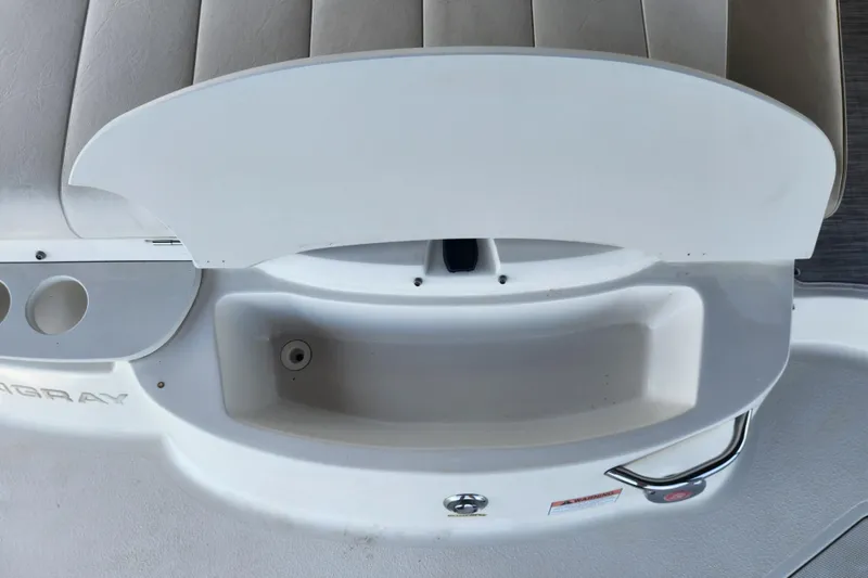 Slide: The Image of 2018 Stingray 235 LR boat interior with storage compartment and seating area. - 56