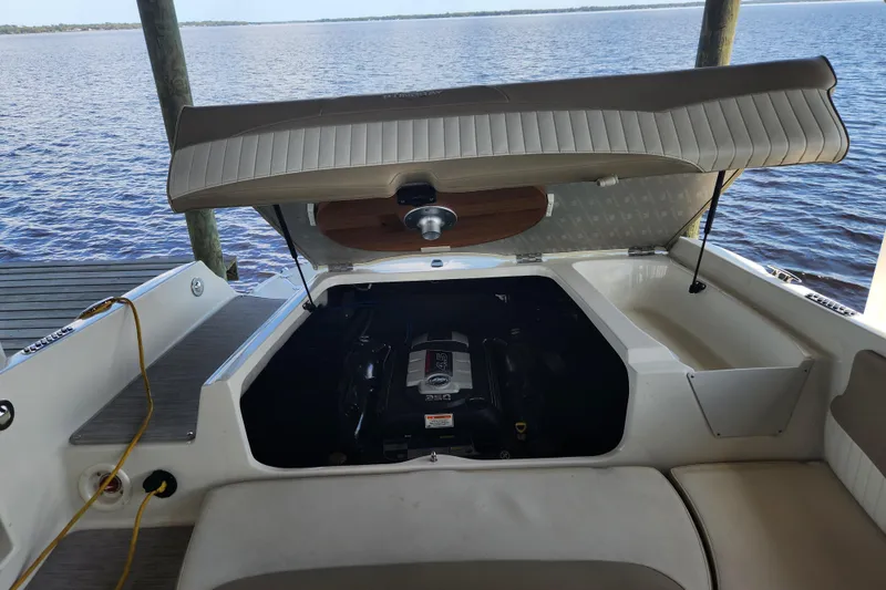 Slide: The Image of Open engine compartment of a 2018 Stingray 235 LR boat by the water. - 59
