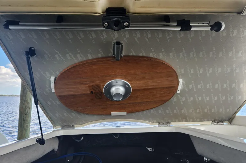 Slide: The Image of 2018 Stingray 235 LR boat hatch with wooden table attachment, open to reveal storage. - 60