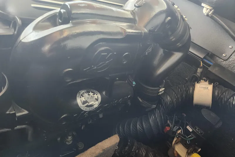 Slide: The Image of Engine compartment of a 2018 Stingray 235 LR boat, showcasing components and emission label. - 64