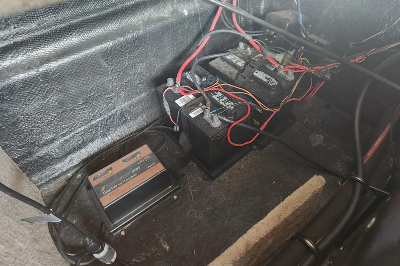 Slide: The Image of Battery compartment of a 2018 Stingray 235 LR boat with wiring and charger. - 67