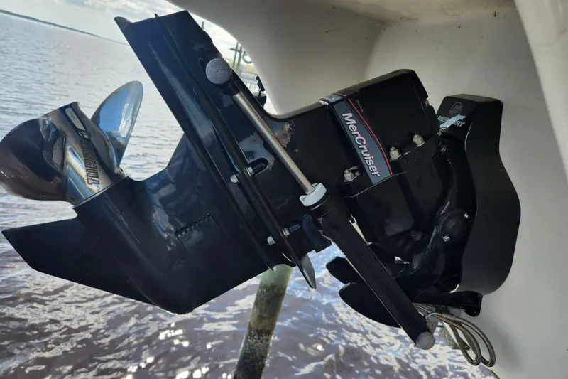 Slide: The Image of 2018 Stingray 235 LR boat with MerCruiser outdrive, propeller visible above water. - 79