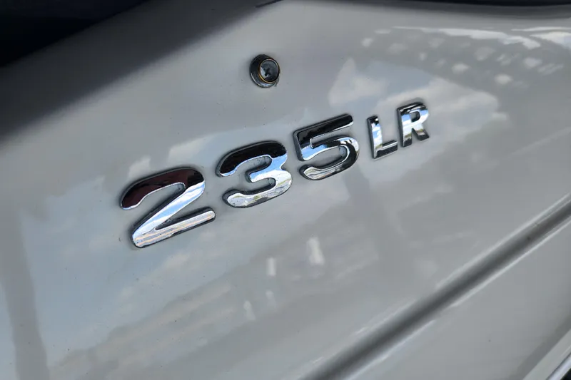 Slide: The Image of 2018 Stingray 235 LR boat model emblem in chrome on white surface. - 89