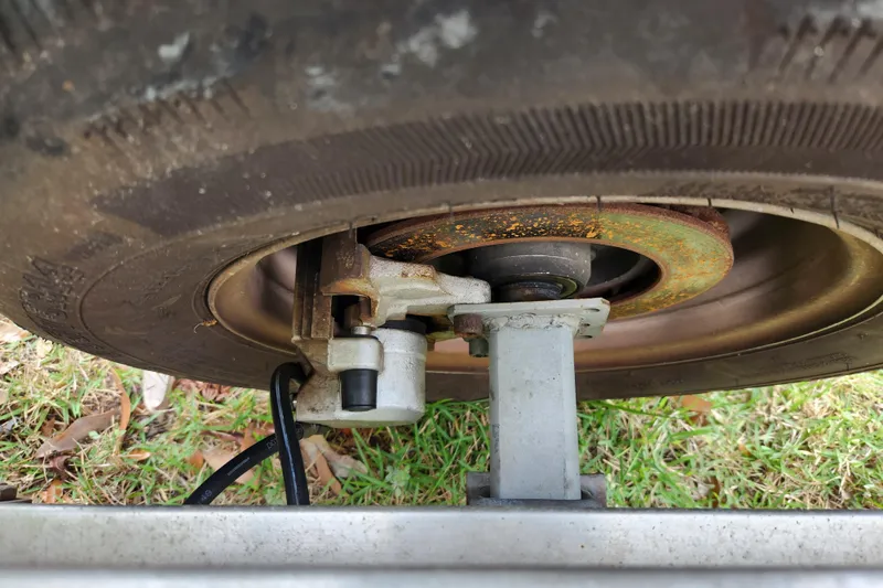Slide: The Image of Close-up of a 2018 Stingray 235 LR trailer wheel and brake mechanism on grass. - 91