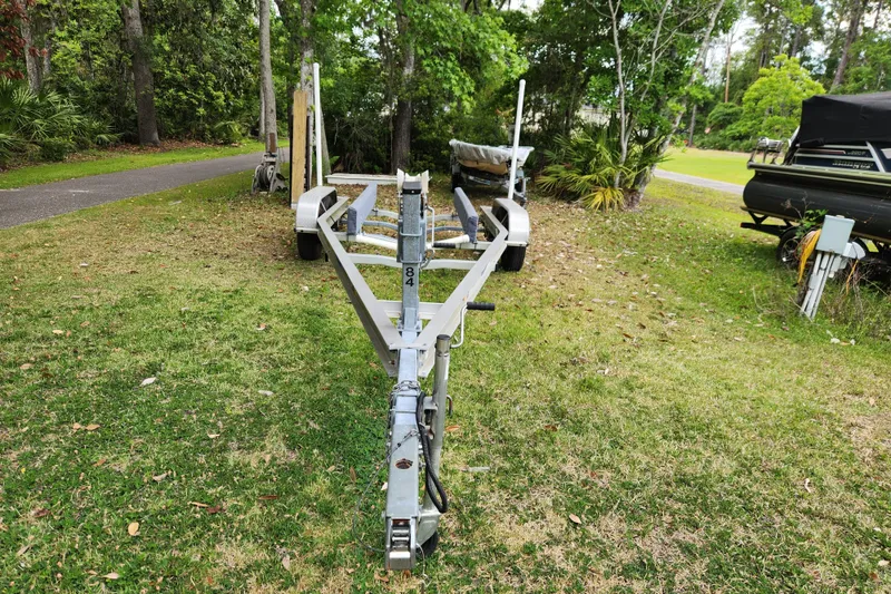 Slide: The Image of Empty boat trailer on grass, surrounded by trees, for 2018 Stingray 235 LR. - 92