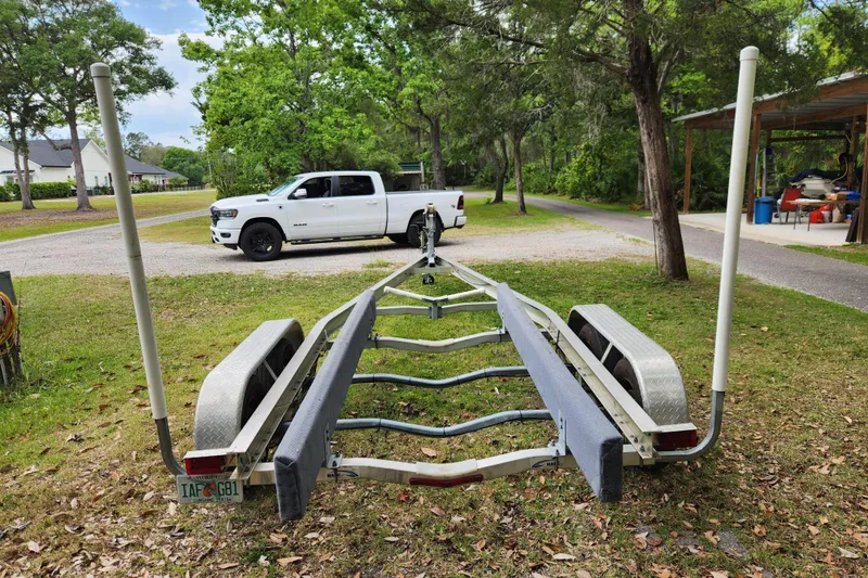 Slide: The Image of Boat trailer for 2018 Stingray 235 LR, parked on grass with a white truck nearby. - 93