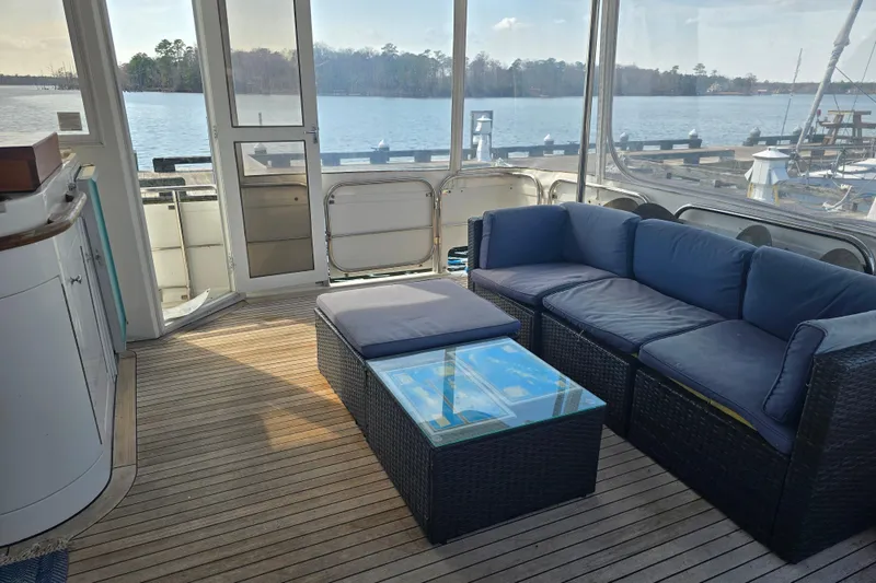 Slide: The Image of Luxurious 1996 President 58 yacht interior with blue seating and glass table, overlooking serene waters. - 24