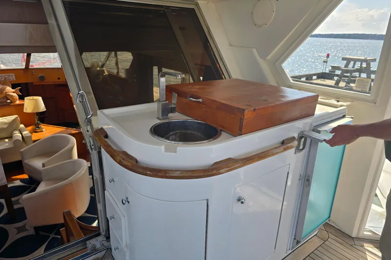 Slide: The Image of 1996 President 58 yacht interior with sink, wooden countertop, and seating area. - 25
