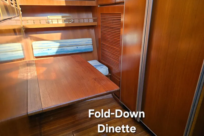 Slide: The Image of Fold-down dinette in 1996 President 58 yacht with wooden interior and blue accents. - 35
