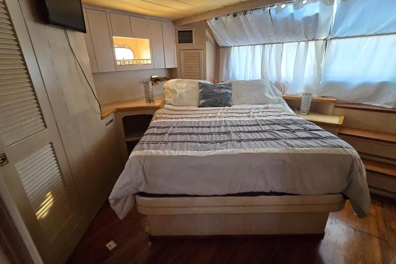 Slide: The Image of Cozy bedroom interior on a 1996 President 58 yacht with elegant bedding and natural light. - 38