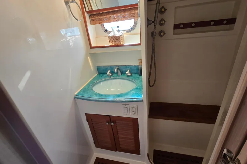 Slide: The Image of Compact bathroom with turquoise countertop, wooden accents, and shower in a 1996 President 58 yacht. - 41
