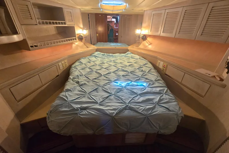 Slide: The Image of Luxurious cabin interior of a 1996 President 58 yacht with cozy bedding and ambient lighting. - 47