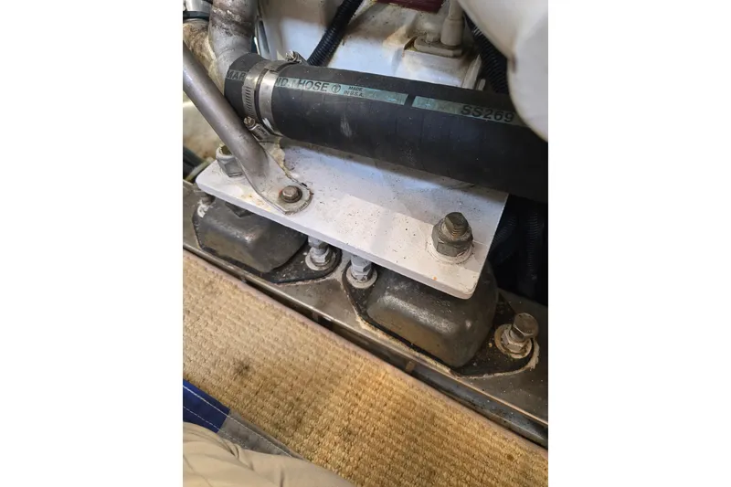 Slide: The Image of Close-up of a 1996 President 58 engine component with hose and bolts. - 61