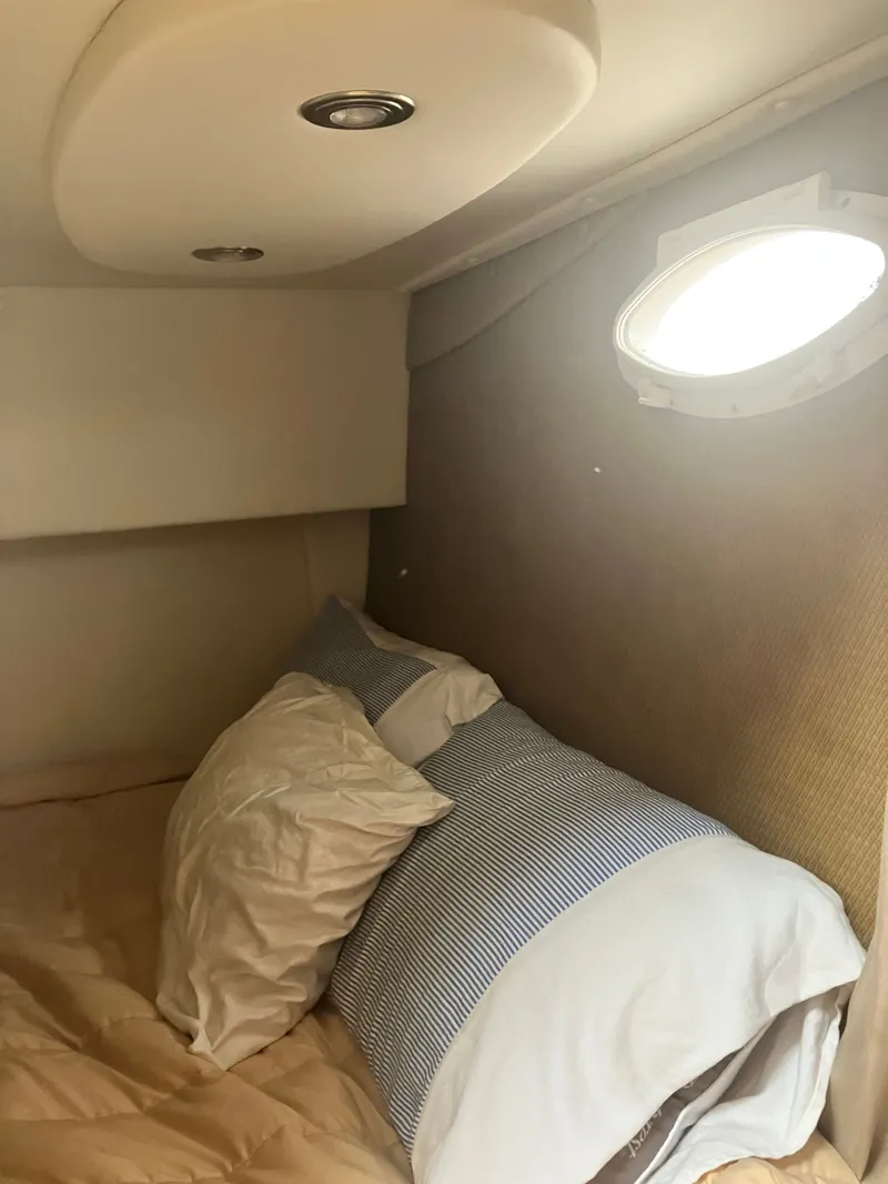 Slide: The Image of Interior of 2008 Rinker 260 Express Cruiser with bed and porthole. - 7