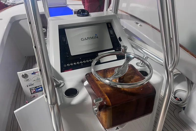 Slide: The Image of 2017 Harrison Boatworks 28 Center Console helm with Garmin display and wooden steering wheel. - 12